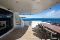 Luxurious 2009 Maiora 31 yacht deck with dining area, overlooking serene ocean view.