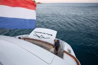 Luxurious 2009 Maiora 31 yacht with flag, cruising on open sea.
