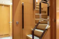 Luxurious wooden staircase inside 2009 Maiora 31 yacht, featuring modern design and elegant finishes.