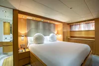 Luxurious bedroom interior on a 2009 Maiora 31 yacht, featuring elegant wood paneling and modern design.