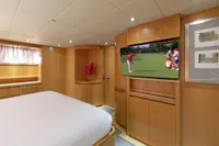Luxurious Maiora 31 yacht bedroom with TV, modern wood paneling, and elegant decor, 2009 model.
