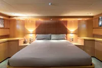 Luxurious bedroom interior on a 2009 Maiora 31 yacht, featuring elegant wood paneling and ambient lighting.