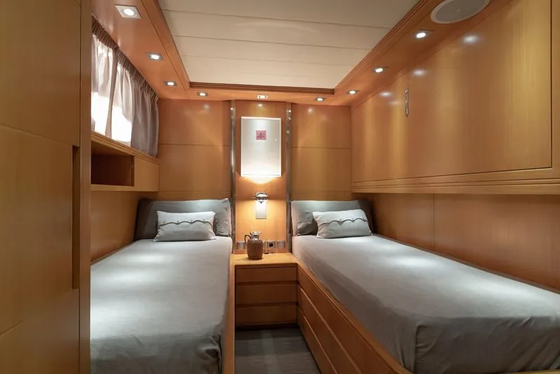  Yacht Photos Pics Luxurious twin cabin interior of 2009 Maiora 31 yacht, featuring elegant wood paneling and ambient lighting.