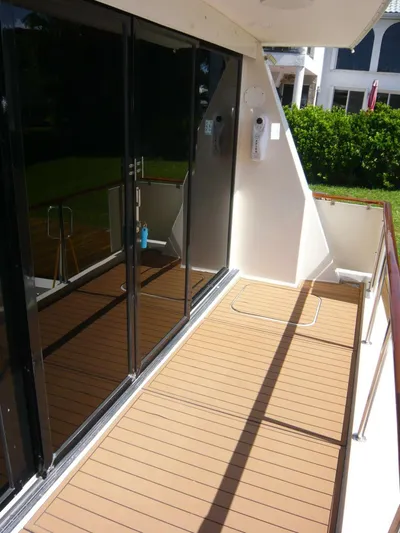 Vitamin Sea Yacht Photos Pics 1990 Viking Cockpit Motor Yacht deck with glass doors and wooden flooring.
