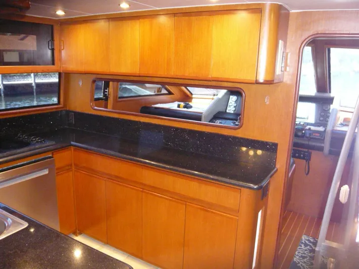 Vitamin Sea Yacht Photos Pics Interior of 1990 Viking Cockpit Motor Yacht with wooden cabinetry and black countertops.