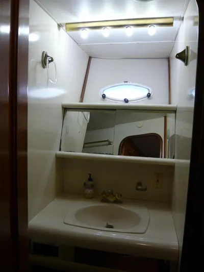 Vitamin Sea Yacht Photos Pics 1990 Viking Cockpit Motor Yacht bathroom with sink, mirror, and lighting.