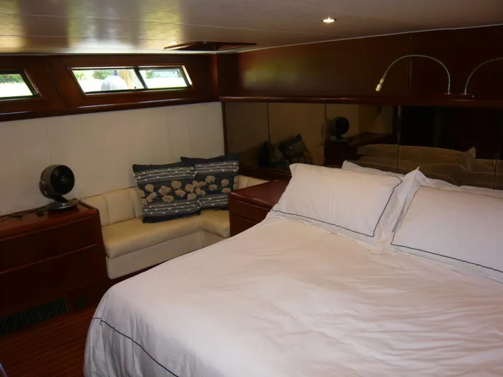Vitamin Sea Yacht Photos Pics Luxurious bedroom interior of 1990 Viking Cockpit Motor Yacht with cozy bed and seating area.