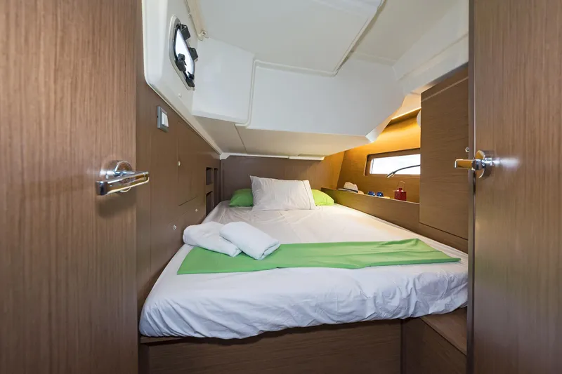  Yacht Photos Pics Cozy cabin interior of 2020 Beneteau Oceanis 46.1 yacht with bed and porthole.