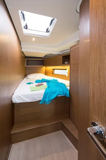  Yacht Photos Pics Cozy cabin interior of 2020 Beneteau Oceanis 46.1 yacht with skylight and wooden finish.