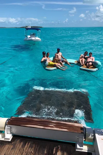  Yacht Photos Pics People relaxing on floats in clear blue water near a Majesty 140 yacht, 2026.