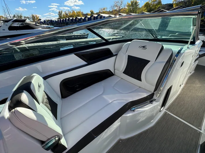 Amoore Yacht Photos Pics 2018 Monterey 328 Super Sport boat interior with white and black seating, docked under a sunny sky.