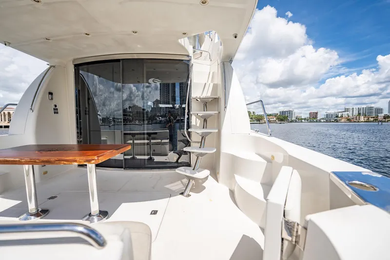 Sound Traveler Yacht Photos Pics 2005 Carver 56 Voyager yacht deck with table, stairs, and waterfront view.