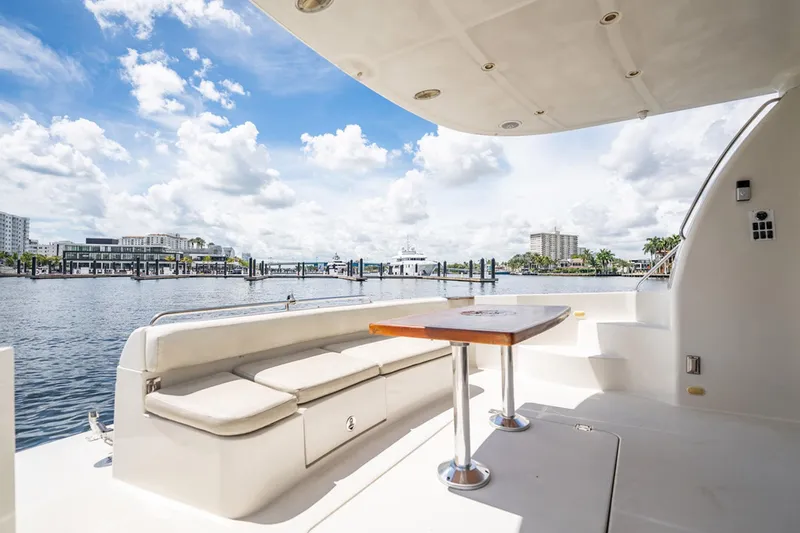 Sound Traveler Yacht Photos Pics 2005 Carver 56 Voyager yacht deck with seating and table, overlooking marina and cityscape.