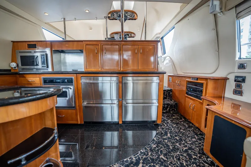 Sound Traveler Yacht Photos Pics Luxurious kitchen interior of 2005 Carver 56 Voyager yacht with modern appliances and wood cabinetry.