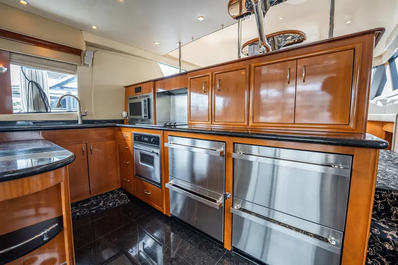 Sound Traveler Yacht Photos Pics Luxurious kitchen interior of 2005 Carver 56 Voyager yacht with wood cabinetry and stainless steel appliances.