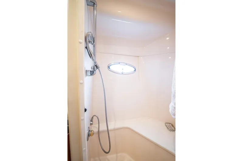 Sound Traveler Yacht Photos Pics Shower area in 2005 Carver 56 Voyager yacht with chrome fixtures and small window.