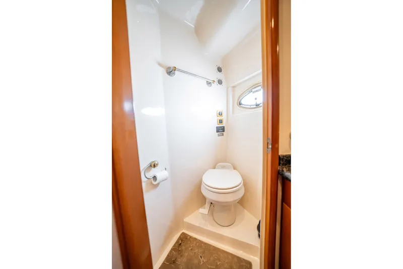Sound Traveler Yacht Photos Pics Compact bathroom in 2005 Carver 56 Voyager yacht with toilet and porthole window.