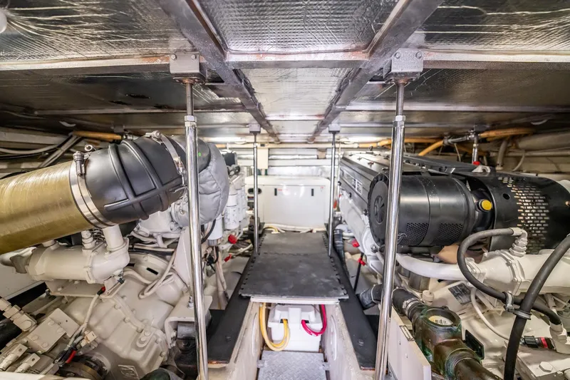 Sound Traveler Yacht Photos Pics Engine room of a 2005 Carver 56 Voyager yacht, showcasing dual engines and mechanical components.