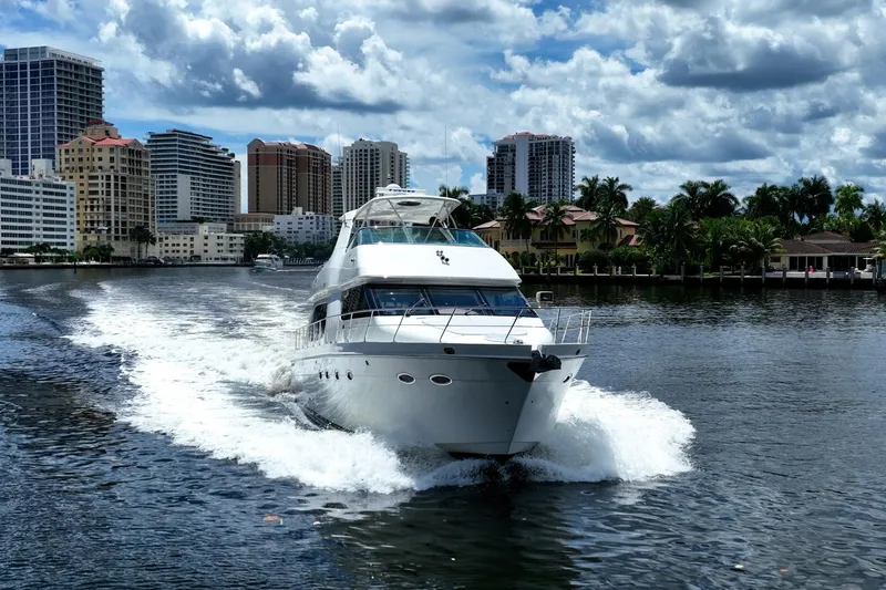 Sound Traveler Yacht Photos Pics 2005 Carver 56 Voyager yacht cruising in urban waterway with city skyline backdrop.