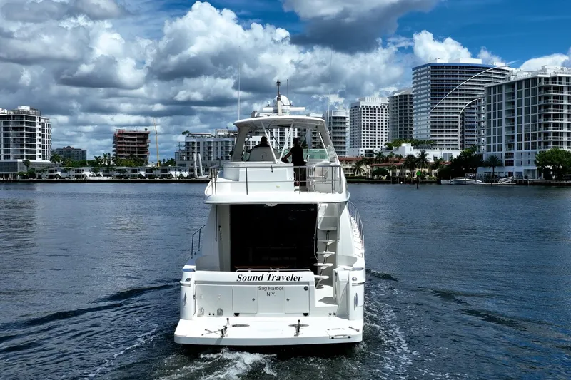 Sound Traveler Yacht Photos Pics 2005 Carver 56 Voyager yacht cruising in urban waterfront setting under cloudy sky.