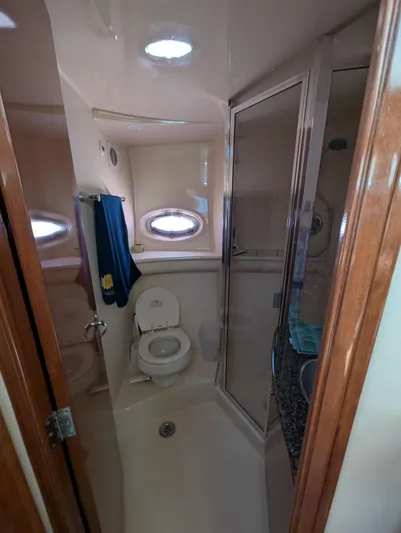Dakota Silver Yacht Photos Pics Compact bathroom in a 2006 Meridian 368 yacht, featuring a toilet, shower, and porthole window.