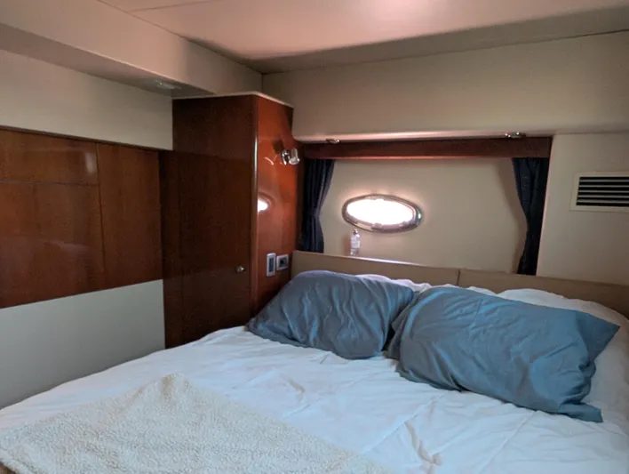 Dakota Silver Yacht Photos Pics Cozy bedroom interior of 2006 Meridian 368 yacht with wooden paneling and porthole window.