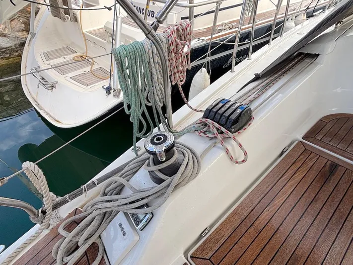 Sunshine Yacht Photos Pics Hanse 345 sailboat deck, 2014 model, featuring ropes and winch on wooden surface.
