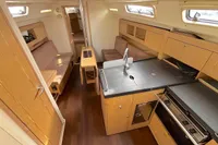 2014 Hanse 345 yacht interior with modern kitchen, wooden cabinetry, and cozy seating area.