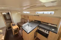 Interior of a 2014 Hanse 345 yacht featuring a modern kitchen and cozy seating area.