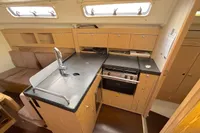 Interior of 2014 Hanse 345 yacht featuring a compact kitchen with wooden cabinetry.