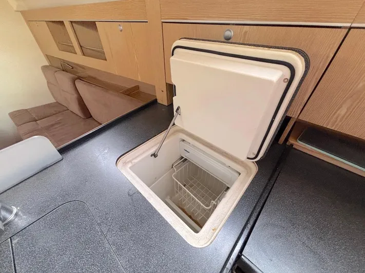 Sunshine Yacht Photos Pics Built-in cooler in 2014 Hanse 345 yacht interior, featuring wooden cabinetry and seating.