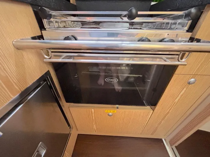 Sunshine Yacht Photos Pics Modern kitchen area in a 2014 Hanse 345 yacht, featuring a sleek oven and cabinetry.