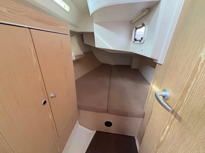 Sunshine Yacht Photos Pics Cozy cabin interior of 2014 Hanse 345 sailboat with wooden cabinetry and comfortable bedding.