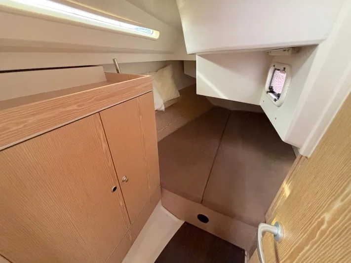 Sunshine Yacht Photos Pics Cozy cabin interior of 2014 Hanse 345 sailboat with wooden cabinetry and bedding.