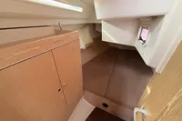 Cozy cabin interior of 2014 Hanse 345 sailboat with wooden cabinetry and bedding.