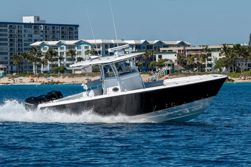  Yacht Photos Pics 2017 Contender 39 ST boat cruising on blue water near coastal buildings.