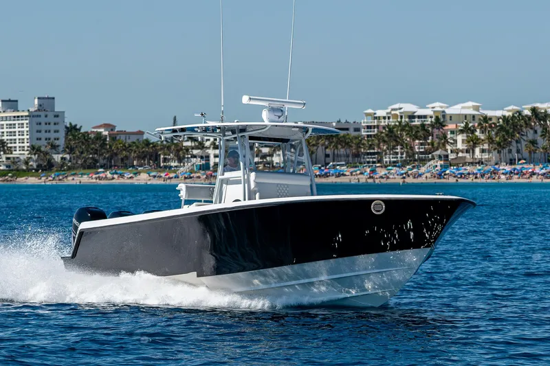  Yacht Photos Pics 2017 Contender 39 ST boat cruising on blue water near a beachside cityscape.