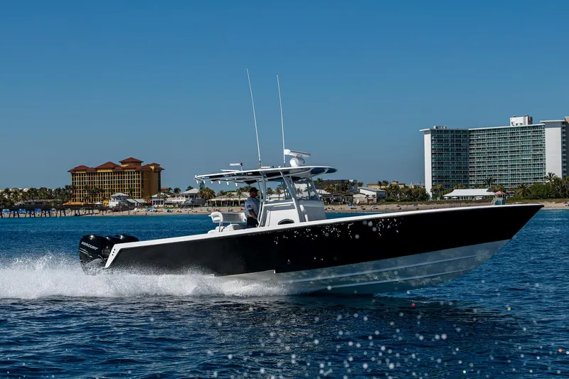  Yacht Photos Pics 2017 Contender 39 ST boat cruising on open water near coastal buildings.