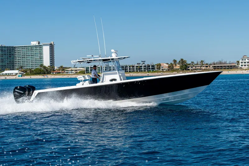  Yacht Photos Pics 2017 Contender 39 ST boat cruising on blue ocean near coastal buildings.