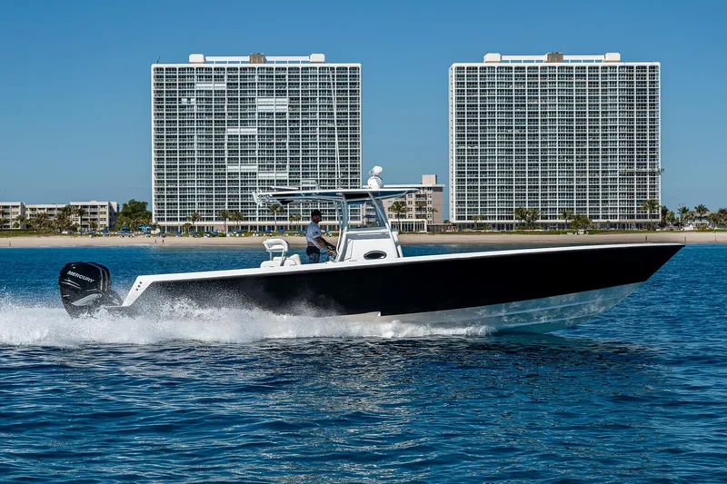  Yacht Photos Pics 2017 Contender 39 ST boat cruising on water with cityscape backdrop.
