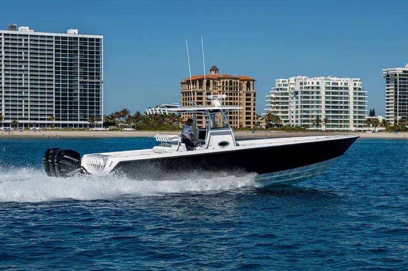  Yacht Photos Pics 2017 Contender 39 ST boat cruising on water near coastal buildings.
