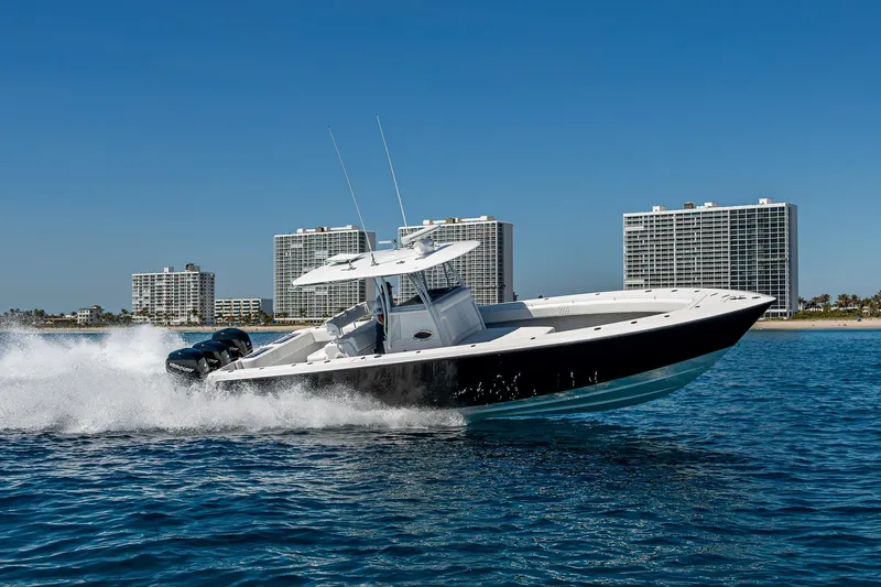  Yacht Photos Pics 2017 Contender 39 ST boat cruising on water with city skyline in background.