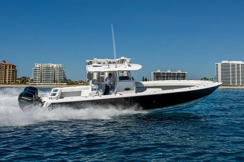  Yacht Photos Pics 2017 Contender 39 ST boat cruising on blue water near coastal buildings.