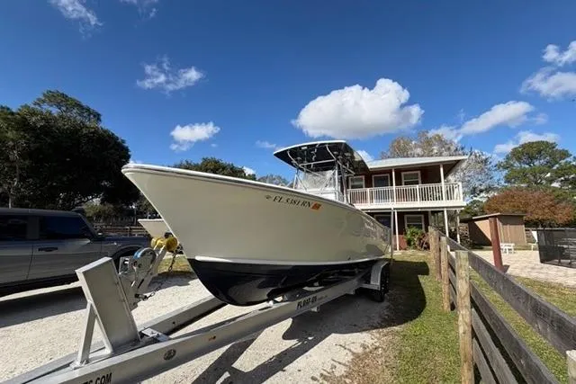  Yacht Photos Pics 2017 Stuart 27 boat on trailer, parked near a house under a clear blue sky.