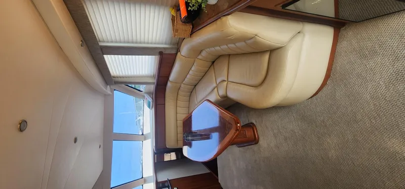  Yacht Photos Pics Interior of 2004 Silverton 48 Convertible yacht with beige leather seating and wooden table.