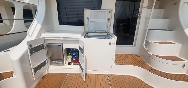 Yacht Photos Pics 2004 Silverton 48 Convertible yacht interior with open storage, refrigerator, and wooden flooring.