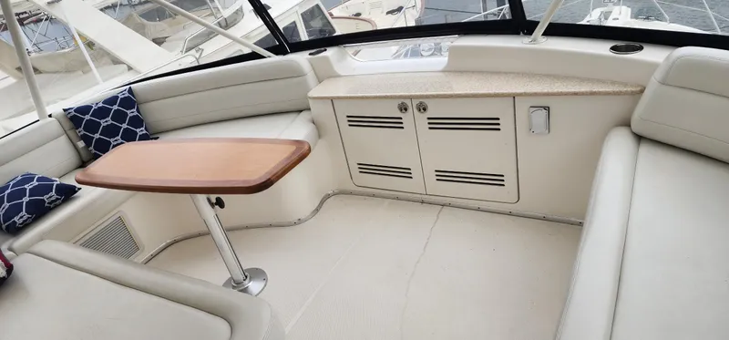  Yacht Photos Pics 2004 Silverton 48 Convertible yacht interior with seating, table, and storage cabinets.