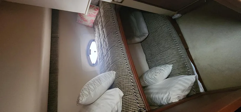  Yacht Photos Pics 2004 Silverton 48 Convertible yacht cabin with twin beds and porthole window.