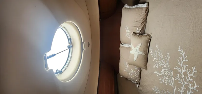  Yacht Photos Pics Interior cabin of 2004 Silverton 48 Convertible yacht with porthole and decorative pillows.