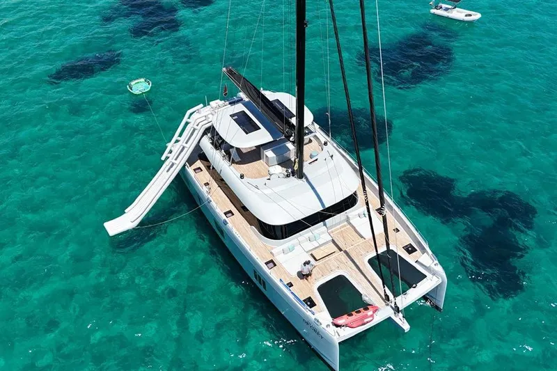Shades Of Grey Yacht Photos Pics 2024 Sunreef 80 sailing yacht with slide on turquoise water.